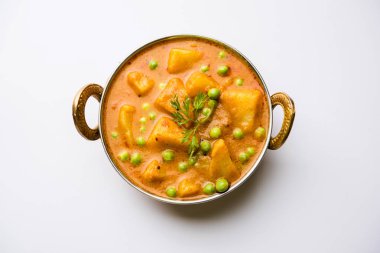 Hint Aloo Mutter köri - patates ve bezelye bir soğan domates et suyu dalmış ve kişniş yaprakları ile süslenmiş. Bir Karahi/kadhai veya pan veya kase servis. seçici odak