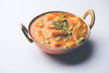 Hint Aloo Mutter köri - patates ve bezelye bir soğan domates et suyu dalmış ve kişniş yaprakları ile süslenmiş. Bir Karahi/kadhai veya pan veya kase servis. seçici odak