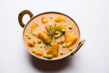Hint Aloo Mutter köri - patates ve bezelye bir soğan domates et suyu dalmış ve kişniş yaprakları ile süslenmiş. Bir Karahi/kadhai veya pan veya kase servis. seçici odak