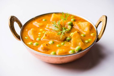 Indian Aloo Mutter curry - Potato and Peas immersed in an Onion Tomato Gravy and garnished with coriander leaves. Served in a Karahi/kadhai or pan or bowl. selective focus clipart