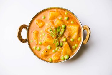 Hint Aloo Mutter köri - patates ve bezelye bir soğan domates et suyu dalmış ve kişniş yaprakları ile süslenmiş. Bir Karahi/kadhai veya pan veya kase servis. seçici odak