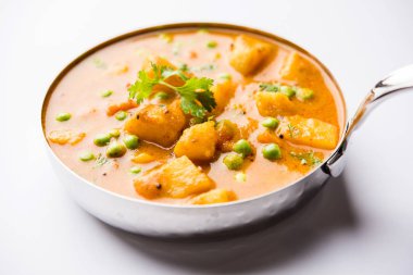 Hint Aloo Mutter köri - patates ve bezelye bir soğan domates et suyu dalmış ve kişniş yaprakları ile süslenmiş. Bir Karahi/kadhai veya pan veya kase servis. seçici odak