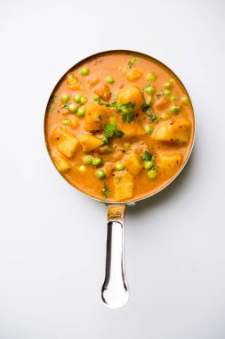 Hint Aloo Mutter köri - patates ve bezelye bir soğan domates et suyu dalmış ve kişniş yaprakları ile süslenmiş. Bir Karahi/kadhai veya pan veya kase servis. seçici odak