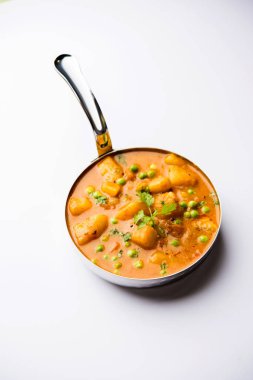 Hint Aloo Mutter köri - patates ve bezelye bir soğan domates et suyu dalmış ve kişniş yaprakları ile süslenmiş. Bir Karahi/kadhai veya pan veya kase servis. seçici odak