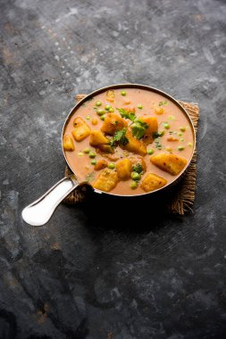 Hint Aloo Mutter köri - patates ve bezelye bir soğan domates et suyu dalmış ve kişniş yaprakları ile süslenmiş. Bir Karahi/kadhai veya pan veya kase servis. seçici odak