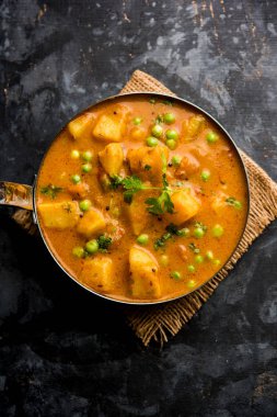 Hint Aloo Mutter köri - patates ve bezelye bir soğan domates et suyu dalmış ve kişniş yaprakları ile süslenmiş. Bir Karahi/kadhai veya pan veya kase servis. seçici odak