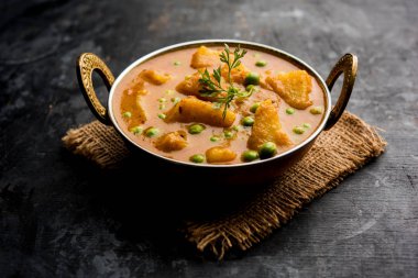 Hint Aloo Mutter köri - patates ve bezelye bir soğan domates et suyu dalmış ve kişniş yaprakları ile süslenmiş. Bir Karahi/kadhai veya pan veya kase servis. seçici odak