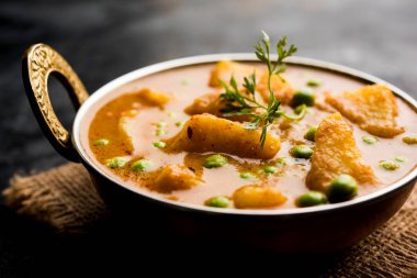 Hint Aloo Mutter köri - patates ve bezelye bir soğan domates et suyu dalmış ve kişniş yaprakları ile süslenmiş. Bir Karahi/kadhai veya pan veya kase servis. seçici odak