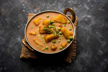 Hint Aloo Mutter köri - patates ve bezelye bir soğan domates et suyu dalmış ve kişniş yaprakları ile süslenmiş. Bir Karahi/kadhai veya pan veya kase servis. seçici odak