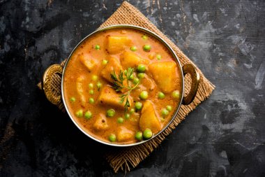 Hint Aloo Mutter köri - patates ve bezelye bir soğan domates et suyu dalmış ve kişniş yaprakları ile süslenmiş. Bir Karahi/kadhai veya pan veya kase servis. seçici odak