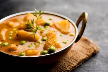 Hint Aloo Mutter köri - patates ve bezelye bir soğan domates et suyu dalmış ve kişniş yaprakları ile süslenmiş. Bir Karahi/kadhai veya pan veya kase servis. seçici odak