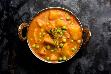 Hint Aloo Mutter köri - patates ve bezelye bir soğan domates et suyu dalmış ve kişniş yaprakları ile süslenmiş. Bir Karahi/kadhai veya pan veya kase servis. seçici odak