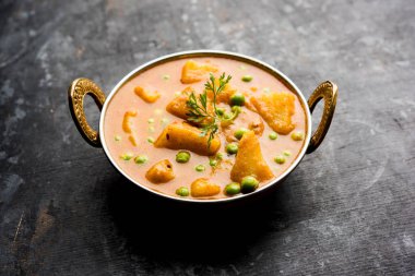 Hint Aloo Mutter köri - patates ve bezelye bir soğan domates et suyu dalmış ve kişniş yaprakları ile süslenmiş. Bir Karahi/kadhai veya pan veya kase servis. seçici odak