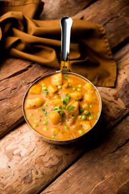 Hint Aloo Mutter köri - patates ve bezelye bir soğan domates et suyu dalmış ve kişniş yaprakları ile süslenmiş. Bir Karahi/kadhai veya pan veya kase servis. seçici odak