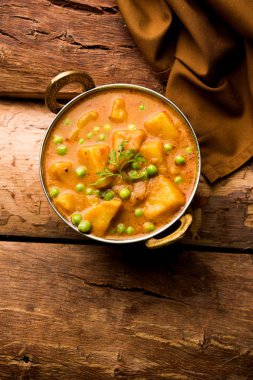 Hint Aloo Mutter köri - patates ve bezelye bir soğan domates et suyu dalmış ve kişniş yaprakları ile süslenmiş. Bir Karahi/kadhai veya pan veya kase servis. seçici odak