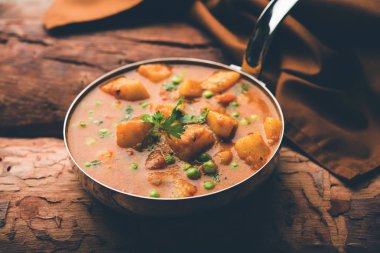 Hint Aloo Mutter köri - patates ve bezelye bir soğan domates et suyu dalmış ve kişniş yaprakları ile süslenmiş. Bir Karahi/kadhai veya pan veya kase servis. seçici odak