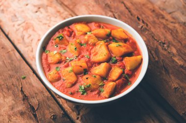 Hint yemeği - Aloo köri masala. Baharatlar ve otlar bir domates köri ile patates pişmiş. bir kapta moody arka plan üzerinde servis. seçici odak