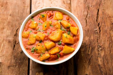 Hint yemeği - Aloo köri masala. Baharatlar ve otlar bir domates köri ile patates pişmiş. bir kapta moody arka plan üzerinde servis. seçici odak