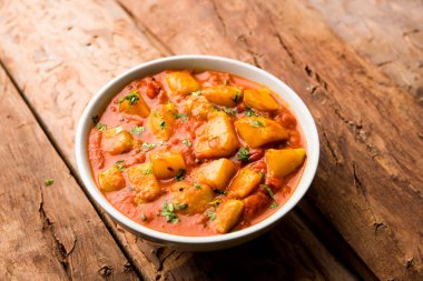 Hint yemeği - Aloo köri masala. Baharatlar ve otlar bir domates köri ile patates pişmiş. bir kapta moody arka plan üzerinde servis. seçici odak