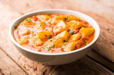 Hint yemeği - Aloo köri masala. Baharatlar ve otlar bir domates köri ile patates pişmiş. bir kapta moody arka plan üzerinde servis. seçici odak