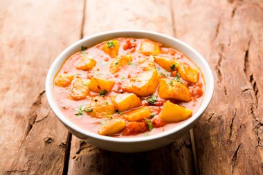 Hint yemeği - Aloo köri masala. Baharatlar ve otlar bir domates köri ile patates pişmiş. bir kapta moody arka plan üzerinde servis. seçici odak