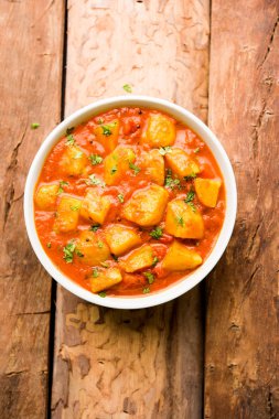 Hint yemeği - Aloo köri masala. Baharatlar ve otlar bir domates köri ile patates pişmiş. bir kapta moody arka plan üzerinde servis. seçici odak