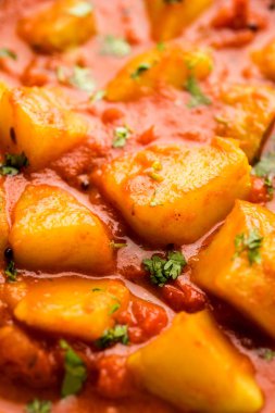 Hint yemeği - Aloo köri masala. Baharatlar ve otlar bir domates köri ile patates pişmiş. bir kapta moody arka plan üzerinde servis. seçici odak