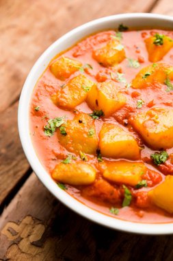 Hint yemeği - Aloo köri masala. Baharatlar ve otlar bir domates köri ile patates pişmiş. bir kapta moody arka plan üzerinde servis. seçici odak