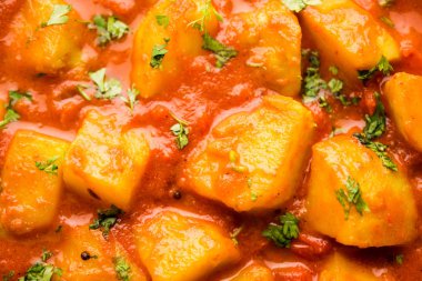 Hint yemeği - Aloo köri masala. Baharatlar ve otlar bir domates köri ile patates pişmiş. bir kapta moody arka plan üzerinde servis. seçici odak