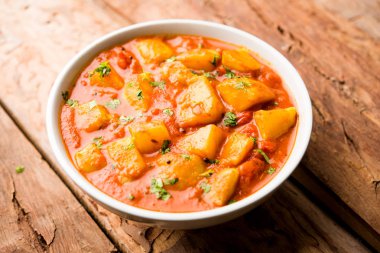 Hint yemeği - Aloo köri masala. Baharatlar ve otlar bir domates köri ile patates pişmiş. bir kapta moody arka plan üzerinde servis. seçici odak