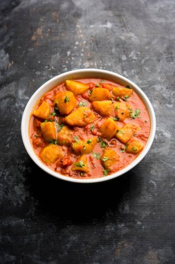 Hint yemeği - Aloo köri masala. Baharatlar ve otlar bir domates köri ile patates pişmiş. bir kapta moody arka plan üzerinde servis. seçici odak