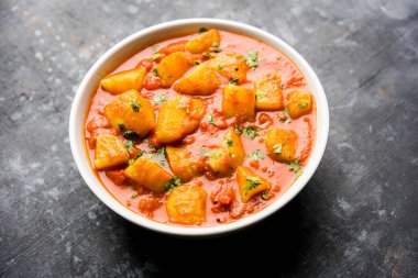 Hint yemeği - Aloo köri masala. Baharatlar ve otlar bir domates köri ile patates pişmiş. bir kapta moody arka plan üzerinde servis. seçici odak
