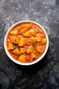 Hint yemeği - Aloo köri masala. Baharatlar ve otlar bir domates köri ile patates pişmiş. bir kapta moody arka plan üzerinde servis. seçici odak