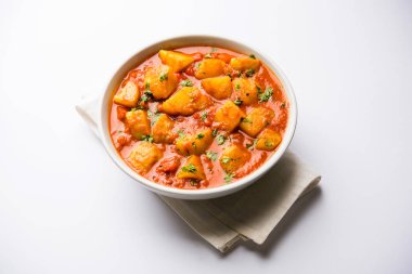 Hint yemeği - Aloo köri masala. Baharatlar ve otlar bir domates köri ile patates pişmiş. bir kapta moody arka plan üzerinde servis. seçici odak