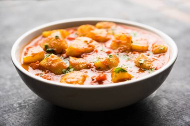 Hint yemeği - Aloo köri masala. Baharatlar ve otlar bir domates köri ile patates pişmiş. bir kapta moody arka plan üzerinde servis. seçici odak