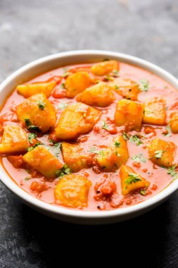 Hint yemeği - Aloo köri masala. Baharatlar ve otlar bir domates köri ile patates pişmiş. bir kapta moody arka plan üzerinde servis. seçici odak