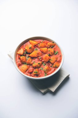 Hint yemeği - Aloo köri masala. Baharatlar ve otlar bir domates köri ile patates pişmiş. bir kapta moody arka plan üzerinde servis. seçici odak