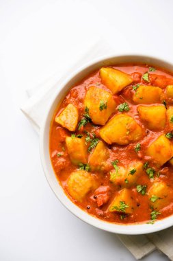 Hint yemeği - Aloo köri masala. Baharatlar ve otlar bir domates köri ile patates pişmiş. bir kapta moody arka plan üzerinde servis. seçici odak