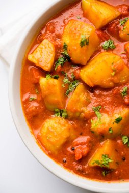 Hint yemeği - Aloo köri masala. Baharatlar ve otlar bir domates köri ile patates pişmiş. bir kapta moody arka plan üzerinde servis. seçici odak