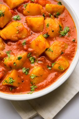 Hint yemeği - Aloo köri masala. Baharatlar ve otlar bir domates köri ile patates pişmiş. bir kapta moody arka plan üzerinde servis. seçici odak