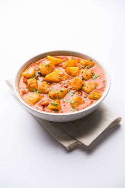 Hint yemeği - Aloo köri masala. Baharatlar ve otlar bir domates köri ile patates pişmiş. bir kapta moody arka plan üzerinde servis. seçici odak