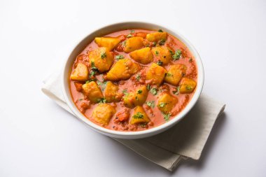 Hint yemeği - Aloo köri masala. Baharatlar ve otlar bir domates köri ile patates pişmiş. bir kapta moody arka plan üzerinde servis. seçici odak