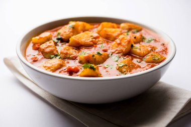 Hint yemeği - Aloo köri masala. Baharatlar ve otlar bir domates köri ile patates pişmiş. bir kapta moody arka plan üzerinde servis. seçici odak