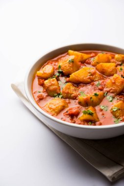 Hint yemeği - Aloo köri masala. Baharatlar ve otlar bir domates köri ile patates pişmiş. bir kapta moody arka plan üzerinde servis. seçici odak