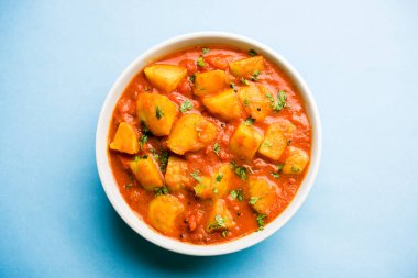 Hint yemeği - Aloo köri masala. Baharatlar ve otlar bir domates köri ile patates pişmiş. bir kapta moody arka plan üzerinde servis. seçici odak