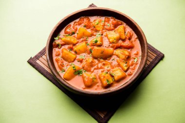 Hint yemeği - Aloo köri masala. Baharatlar ve otlar bir domates köri ile patates pişmiş. bir kapta moody arka plan üzerinde servis. seçici odak