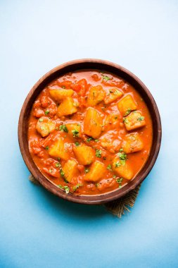Hint yemeği - Aloo köri masala. Baharatlar ve otlar bir domates köri ile patates pişmiş. bir kapta moody arka plan üzerinde servis. seçici odak