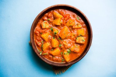 Hint yemeği - Aloo köri masala. Baharatlar ve otlar bir domates köri ile patates pişmiş. bir kapta moody arka plan üzerinde servis. seçici odak