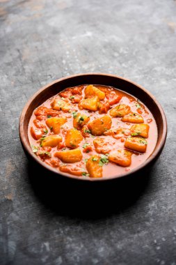 Hint yemeği - Aloo köri masala. Baharatlar ve otlar bir domates köri ile patates pişmiş. bir kapta moody arka plan üzerinde servis. seçici odak