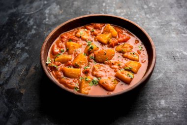 Hint yemeği - Aloo köri masala. Baharatlar ve otlar bir domates köri ile patates pişmiş. bir kapta moody arka plan üzerinde servis. seçici odak